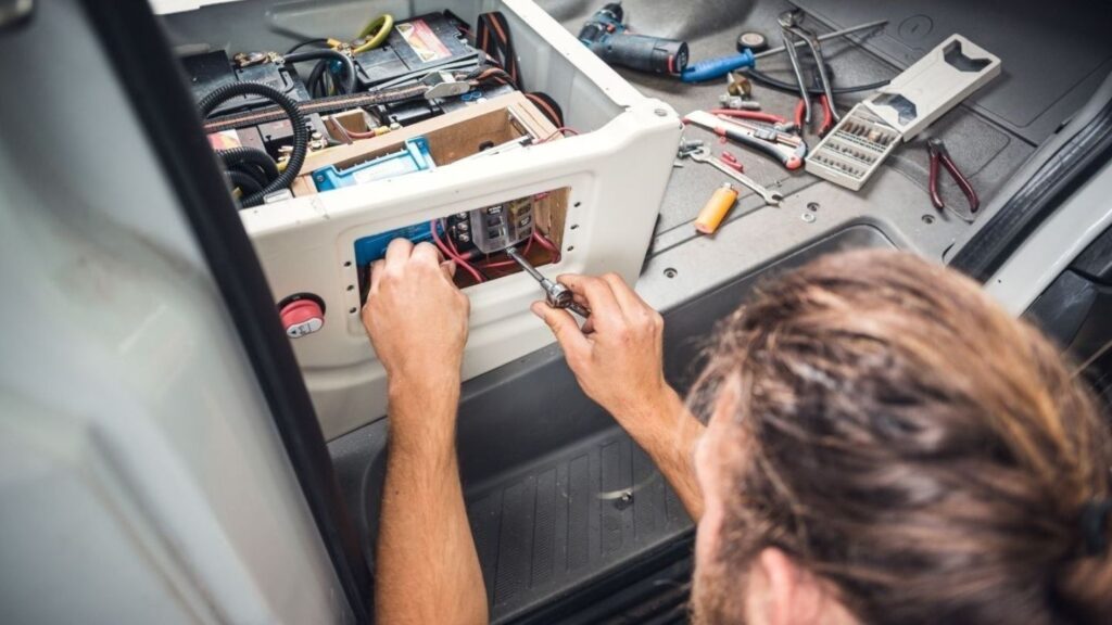 Technician performing mobile RV electrical system repair at Charlotte-area campground