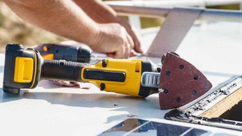 Mobile RV technician sealing RV roof leak at campground in Charlotte