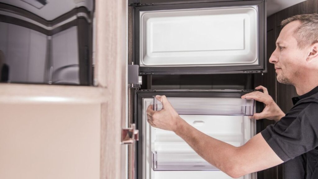 RV owner checking broken refrigerator before mobile appliance repair