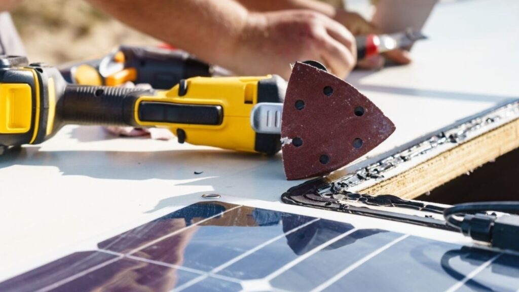 Close-up of RV roof resealing process using white rubberized coating